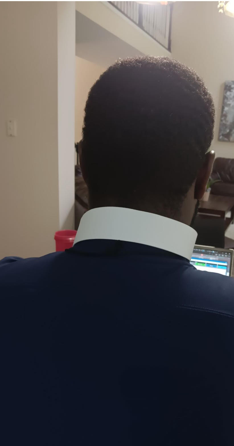 A clergy member seated with a laptop.